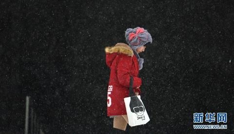 12月10日，一位沈阳市民走在雪中。
